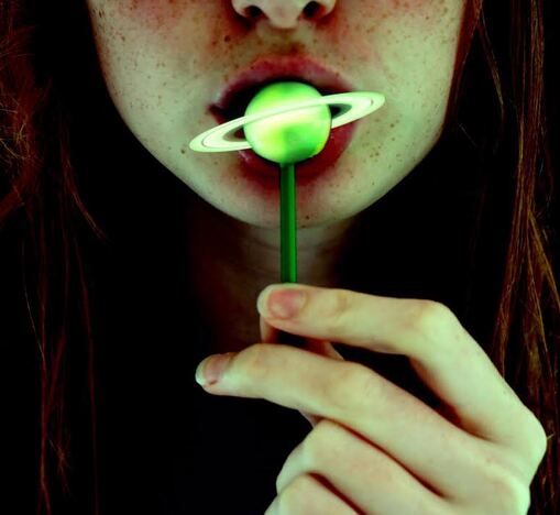 Edited photograph of a girl with Saturn as a lollipop